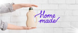 A man holding a detergent bottle depicting the easy guide to homemade dishwasher detergent.