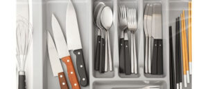 Clean and neatly organized cutlery in a rack depicting The Dishwasher's Impact on Knives