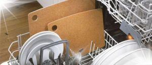 Visual representation of Can I Put My Cutting Board in the Dishwasher featuring a dishwasher filled with dishes and prominently displayed cutting boards.