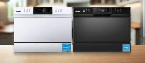 A featured image of the topic COMFEE ‎CDC22P2AWW Dishwasher Review or COMFEE ‎CDC22P1BBB Dishwasher Review - Side-by-side view of two COMFEE countertop dishwashers, one in white (CDC22P2AWW) and one in black (CDC22P1BBB), both featuring a sleek rectangular design with digital display panels and control buttons on top. Both models are ENERGY STAR certified, shown in a modern kitchen setting with a wooden counter.