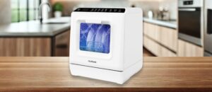 The featured image of ChuMaste CM-XWJ01 Dishwasher Review. It sits sleekly on a wooden kitchen counter, with a modern, compact design perfect for small spaces. Its control panel is clearly visible on top, while the front window shows dishes being sprayed with water inside, giving a real sense of its cleaning action in a cozy kitchen setting.