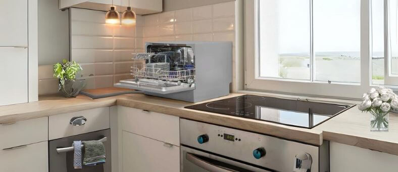 A sleek, modern kitchen featuring the best countertop dishwashers open and loaded, highlighting space-efficient design.