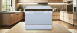 In this SPT SD-2224DSB Dishwasher Review image, the countertop (compact / benchtop) dishwasher is displayed on a counter in a kitchen, showcasing its stylish appearance and practical placement for everyday use.