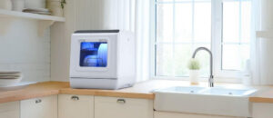 Best sterilizing countertop dishwashers displayed in a bright modern kitchen, featuring a compact unit with blue glow beside a wide sink and window.