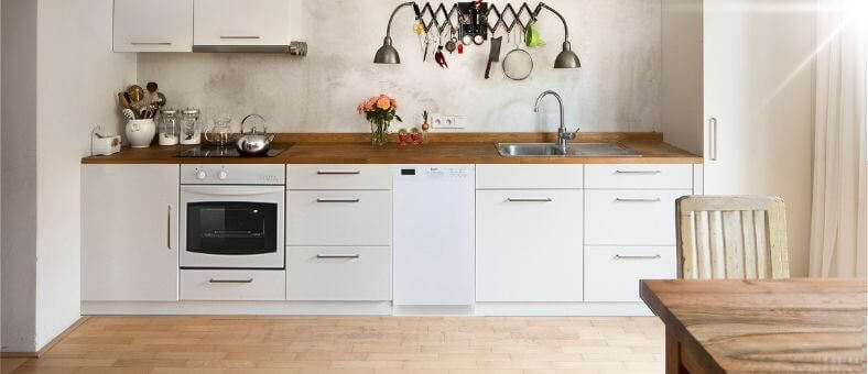 A sleek, contemporary kitchen with built-in cabinetry, integrated appliances, and a modern sink setup. The Avanti DWF24V0W dishwasher is seamlessly installed within the cabinetry, demonstrating its compatibility with clean, minimalist kitchen designs.