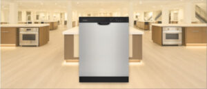 In this Amana ADB1400AMS Dishwasher Review image, the built-in (under-counter) dishwasher is displayed in a showroom setting, highlighting its modern design and front panel.