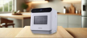 In this Hamilton Beach (RCA) RDW3216 Dishwasher Review image, the countertop (compact / benchtop) dishwasher is displayed on a counter in a kitchen, showcasing its stylish appearance and practical placement for everyday use.