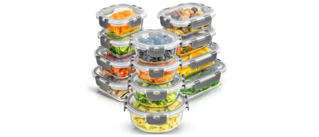 A variety pack of JoyJolt borosilicate glass food storage containers with secure gray locking lids, filled with colorful fresh food items.