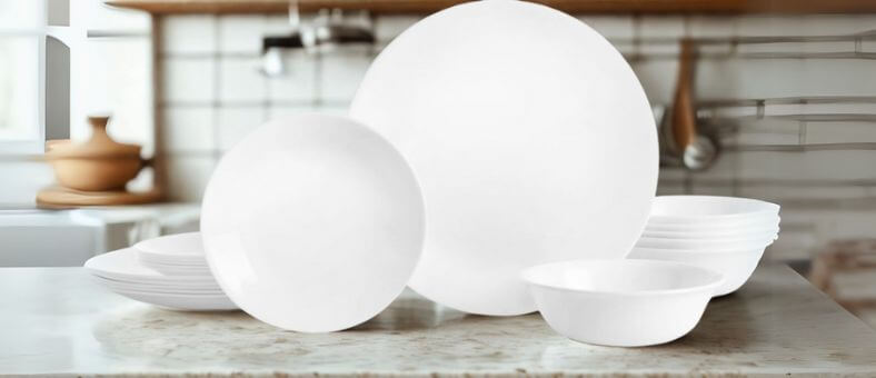 Corelle Vitrelle 18-piece dishwasher-safe dinnerware set featuring lightweight, durable white plates and bowls displayed on a kitchen counter.