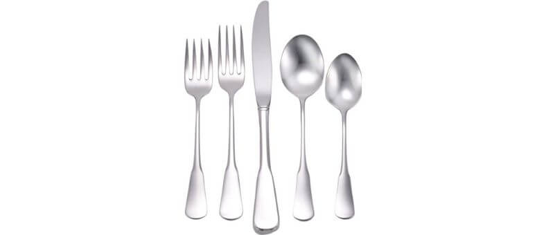 Liberty Tabletop Chesapeake flatware set with 40 stainless steel utensils aligned diagonally, highlighting their unique curvature and brushed finish.