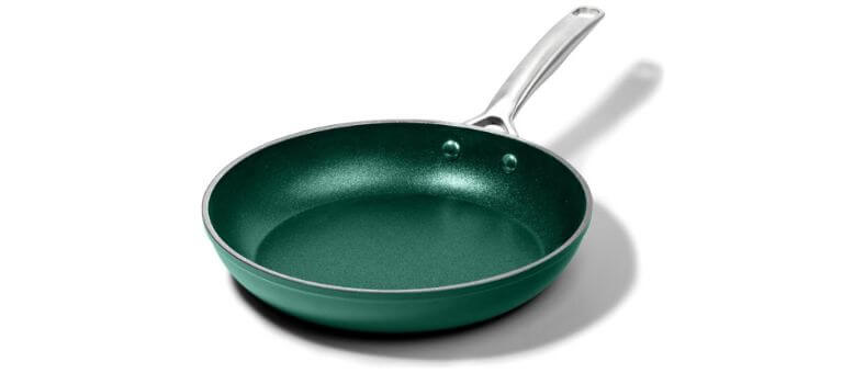 A vibrant green nonstick frying pan with a metallic finish and silver handle, casting a soft shadow on a white surface.