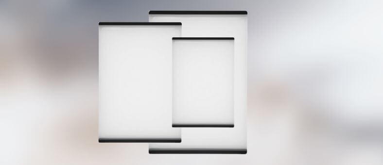 A clean, minimalistic set of two white plastic cutting boards with black, non-slip edges, ideal for everyday kitchen use.