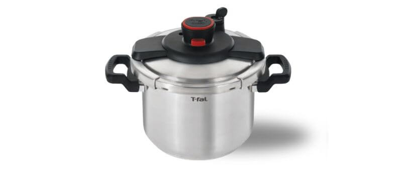 Top view of a T-fal stainless steel pressure cooker with black handles and red pressure indicator.