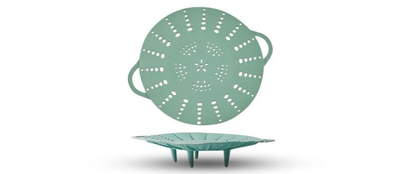 Image shows two stacked views of a large teal silicone steamer basket with side handles and vent holes.