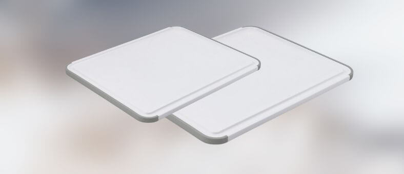 Two rectangular plastic cutting boards with grooved edges and soft gray corners, designed for stable cutting and chopping.
