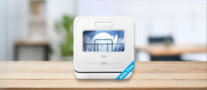 In this Midea MDC17P4CWW Dishwasher Review image, the countertop (compact / benchtop) dishwasher is displayed on a counter in a kitchen, showcasing its stylish appearance and practical placement for everyday use.