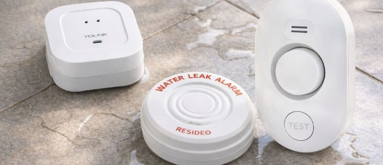 Best Water Leak Detectors for Home Protection – Yolink and Resideo devices shown on wet floor detecting water leaks.