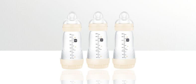 MAM Anti-Colic Baby Bottles – Three clear baby bottles with beige caps, shown on a white reflective background.