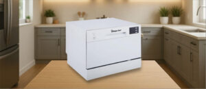 In this Magic Chef MCSCD6W5 Dishwasher Review image, the countertop (compact / benchtop) dishwasher is displayed on a counter in a kitchen, showcasing its stylish appearance and practical placement for everyday use.