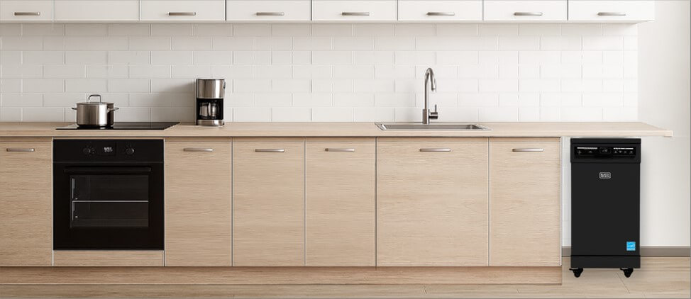 A bright, contemporary kitchen with built-in cabinetry and modern appliances. In the corner, the freestanding BLACK+DECKER BPD8B dishwasher stands independently on its wheels, offering both mobility and functionality without disrupting the clean, open kitchen layout.