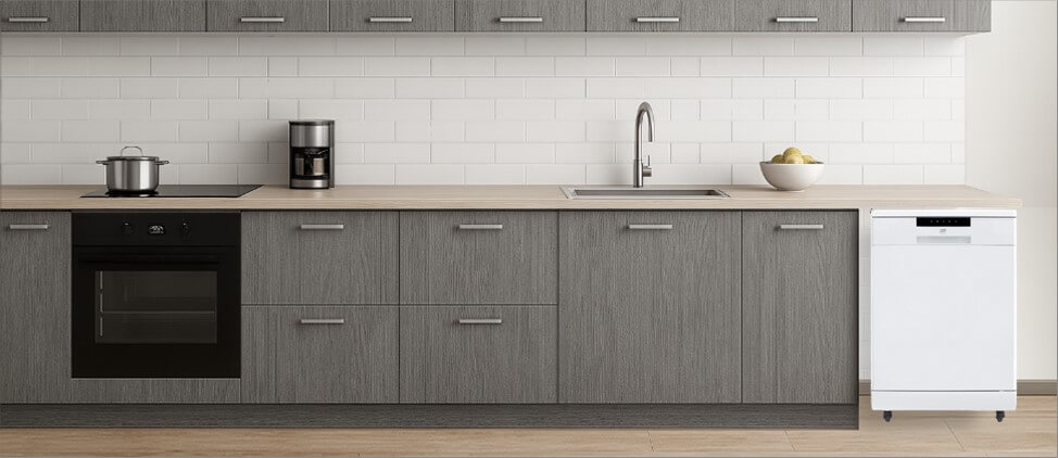 A stylish kitchen setup with integrated appliances and a spacious layout. The freestanding SPT SD-6513W dishwasher is placed at the corner, showcasing its versatility and ease of placement, perfect for kitchens where built-in installation isn’t required.