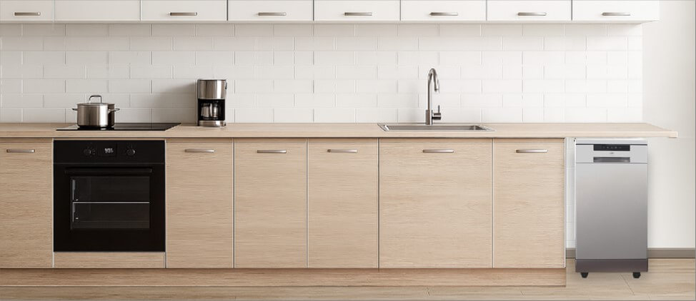 A stylish kitchen setup with integrated appliances and a spacious layout. The freestanding SPT SD-9263SSB dishwasher is placed at the corner, showcasing its versatility and ease of placement, perfect for kitchens where built-in installation isn’t required.