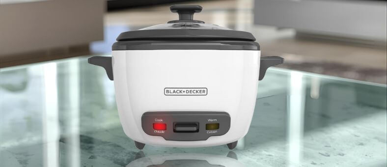 BLACK+DECKER dishwasher safe rice cooker with cook and warm settings on a glass countertop.