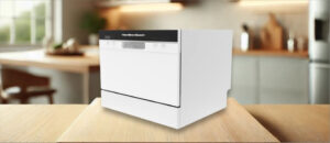 HAMILTON BEACH HBDW3208 Dishwasher Review image showing the countertop (tabletop / benchtop) dishwasher set up on a kitchen counter, drawing attention to its minimal footprint and user-friendly front panel.