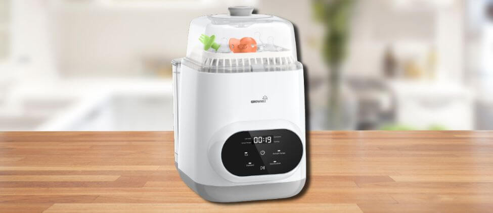 In this Grownsy EaseClean Baby Bottle Washer Review image, the washer is placed on a wooden kitchen counter, highlighting its sleek design and practical countertop placement for everyday use.