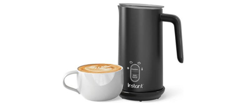 Instant Pot electric milk frother with sleek black design beside a cappuccino cup.