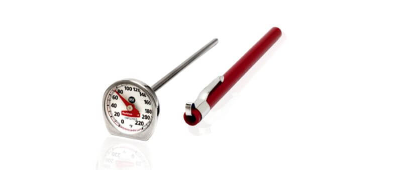 A stainless steel instant-read meat thermometer with a red protective sleeve for easy storage and quick temperature checks.